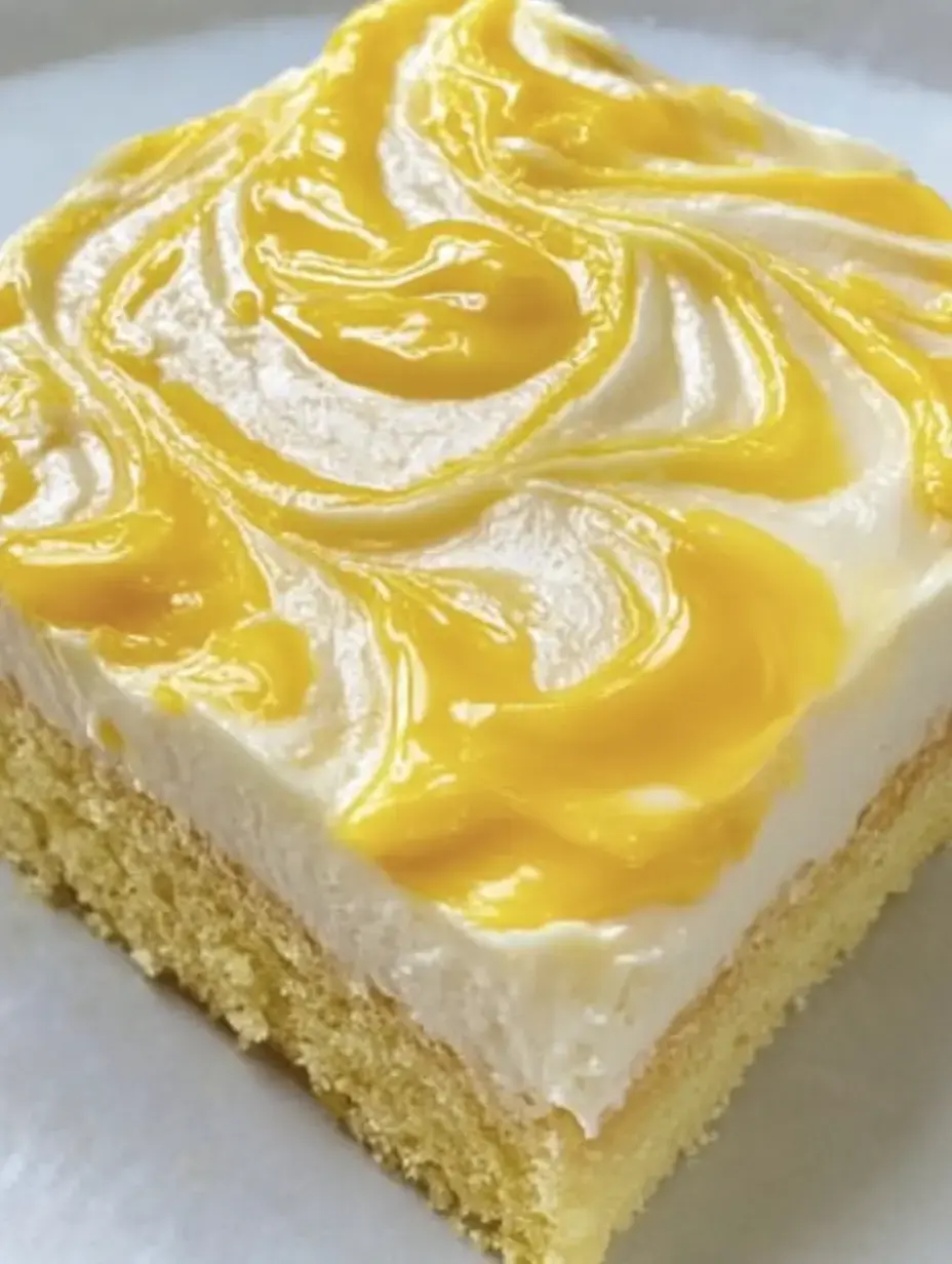 Une part de gâteau avec une couche blanche crémeuse et une sauce fruitée jaune sur le dessus.