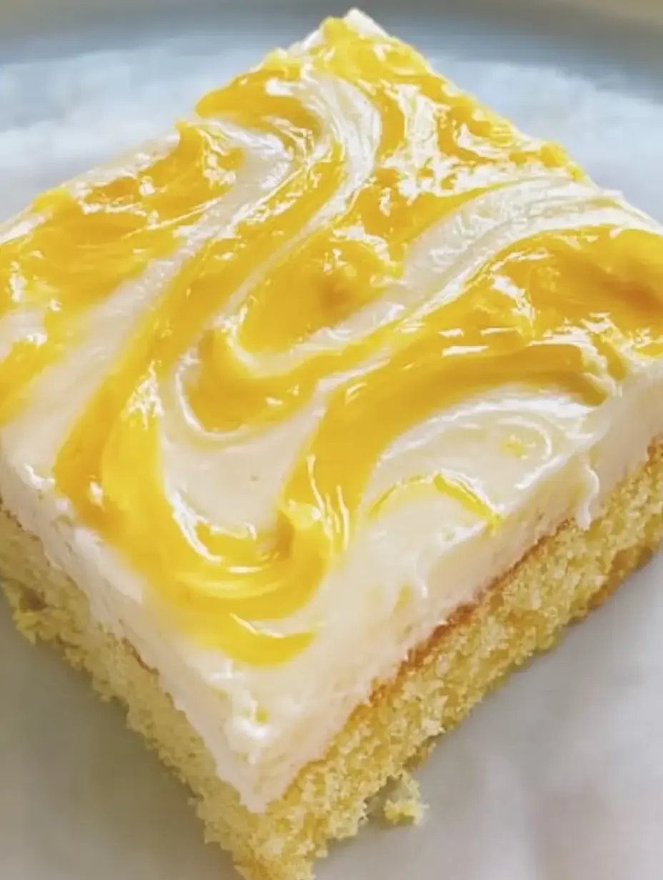 Une part de gâteau moelleux avec un nappage crémeux blanc et jaune.