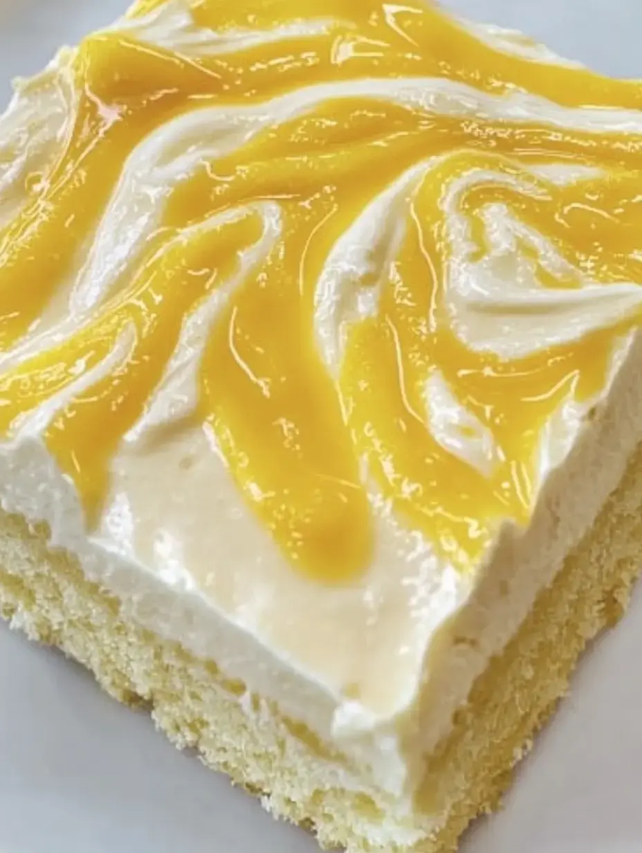 Une part de gâteau avec une couche crémeuse et une sauce fruitée jaune par-dessus.
