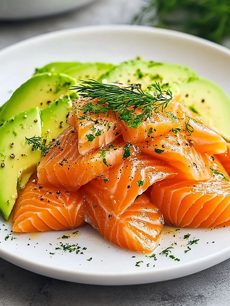 A white plate with a variety of food items including fish, avocado, and possibly other vegetables.