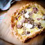 A close up of a tarte feuilletée with mushrooms and sausage.