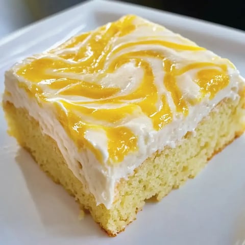 Un dessert avec un glaçage crémeux et des détails de curd, présenté sur une assiette blanche.
